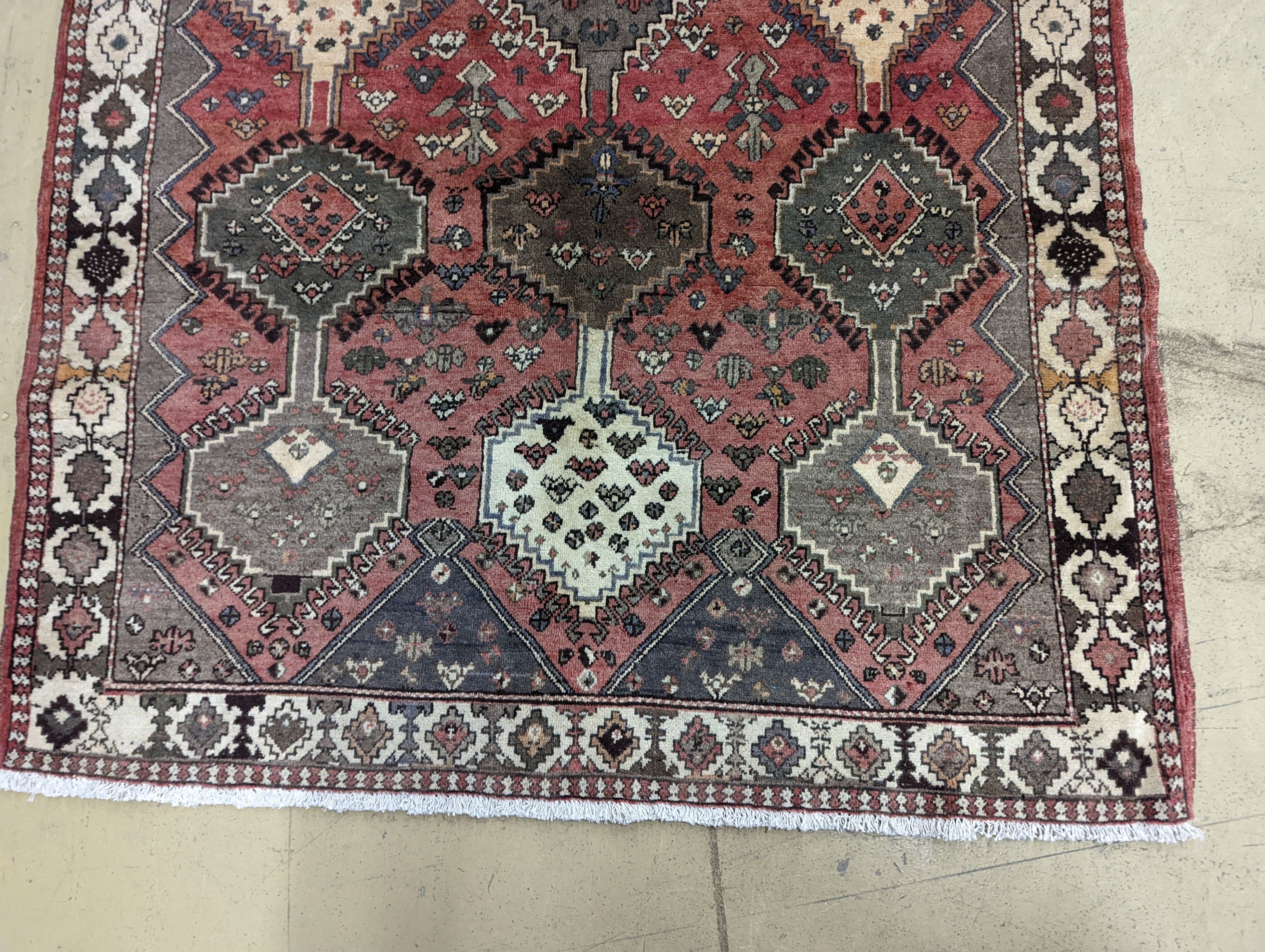 A Persian Shiraz red ground rug, 280 x 150cm